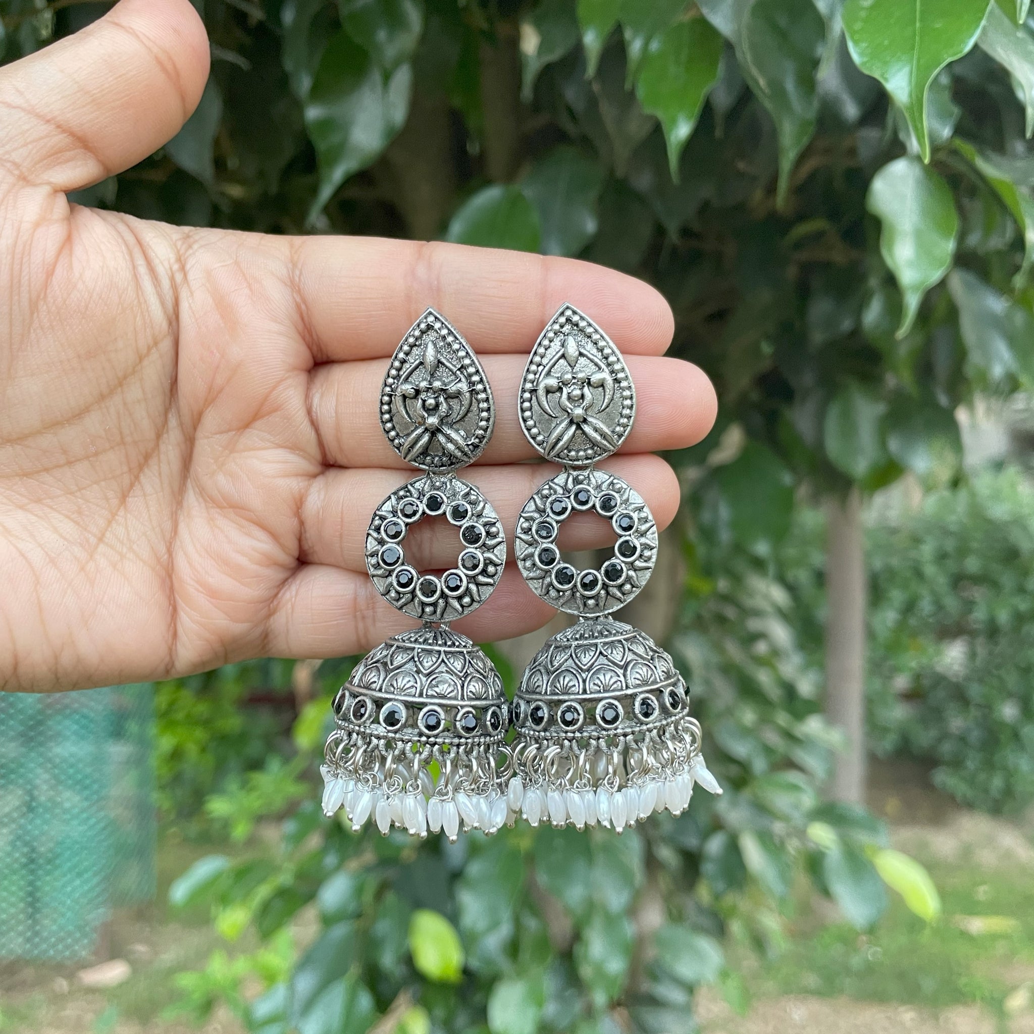 Beautiful silver-plated Jhumka earrings with intricate floral, triangular,  and circular designs. – Rigouts – Remembering the roots.